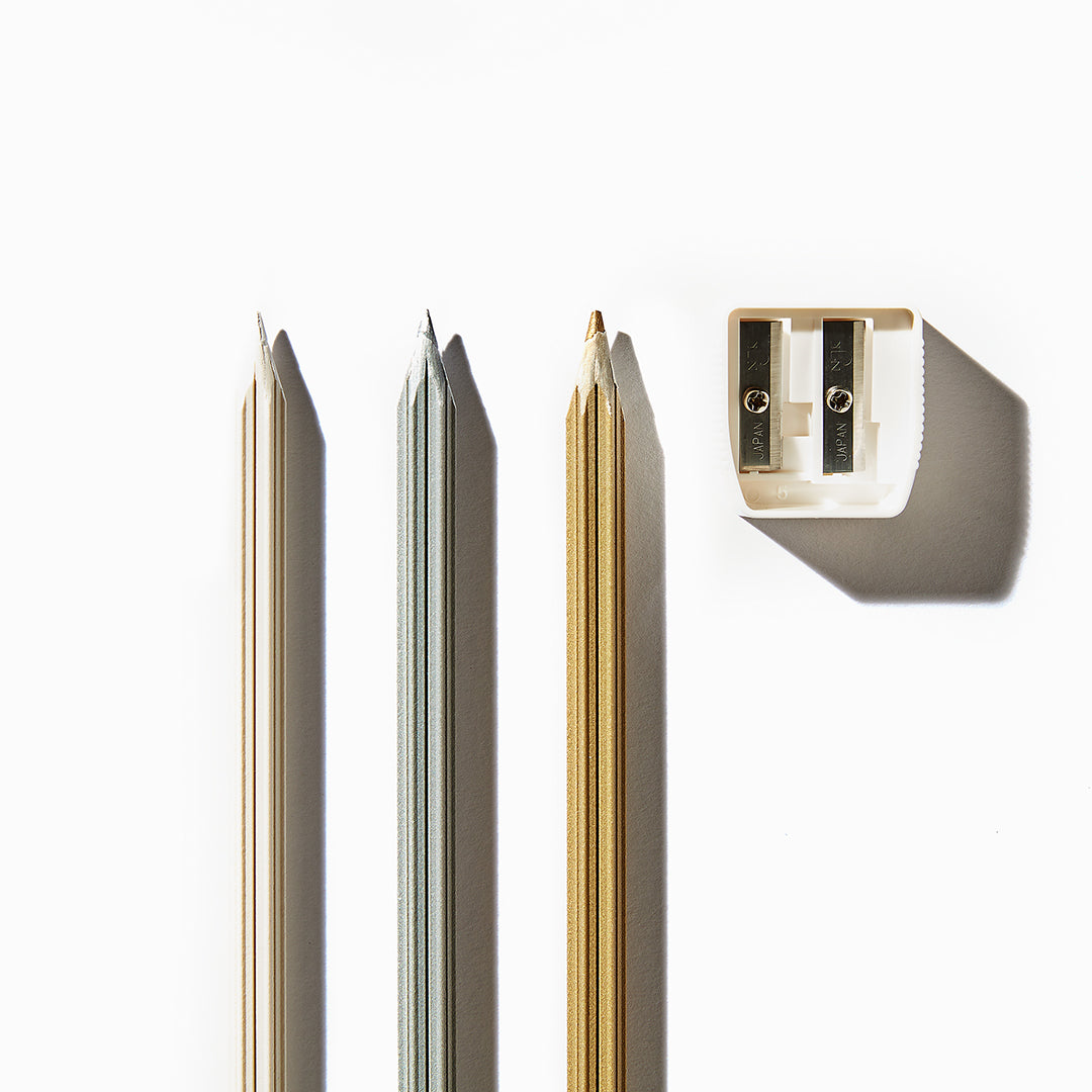 雪色鉛筆3色と鉛筆削りの写真