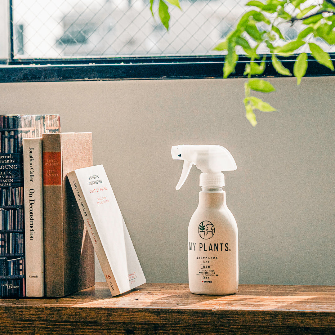 シンプルなデザインのボトルの「MY PLANTS 虫からやさしく守るミスト」が、窓際に本と並べておかれている様子。